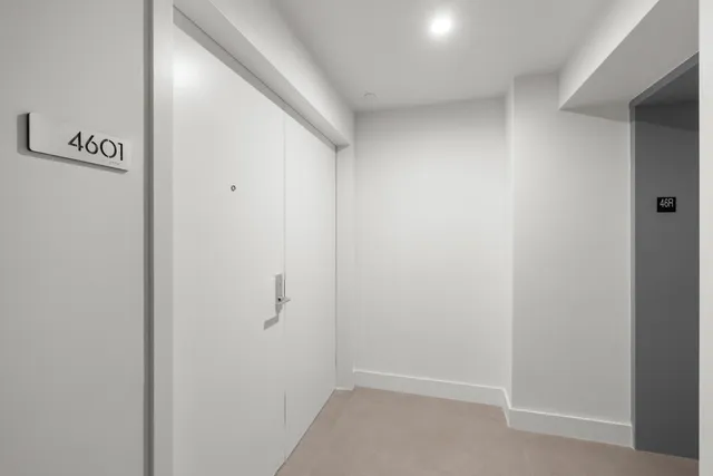 a view of an empty room with a cabinet and a window