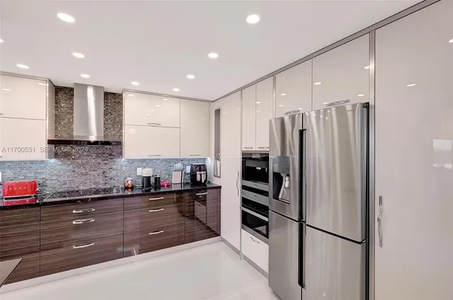 a kitchen with stainless steel appliances granite countertop a refrigerator and a sink