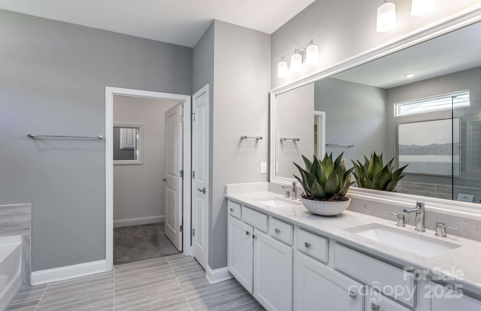 4796 Formation Court, Unit 68 Lancaster, SC 29720 - Photo 11 of 17 a spacious bathroom with a granite countertop sink and a mirror