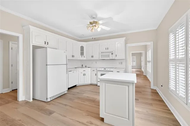 a kitchen with white cabinets and white appliances