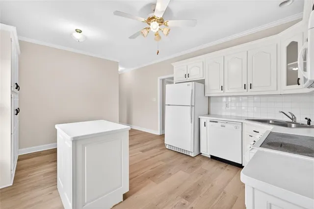 a kitchen with granite countertop white cabinets and white appliances