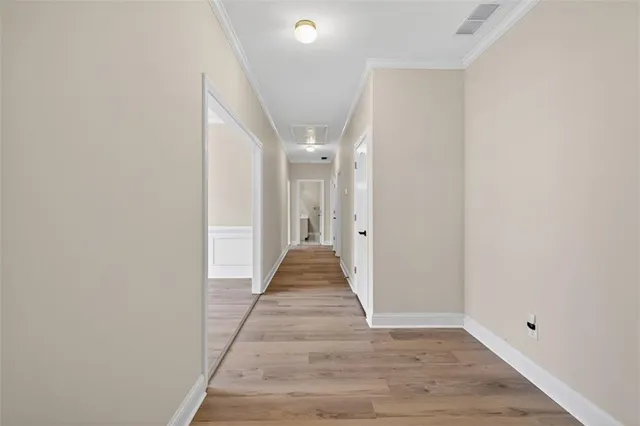 a view of a hallway with wooden floor and staircase