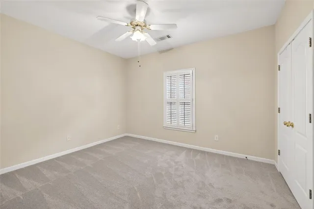 an empty room with chandelier fan