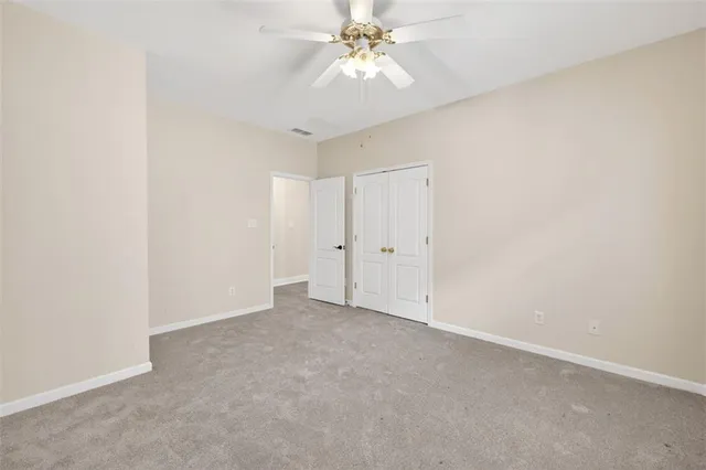 an empty room with chandelier fan