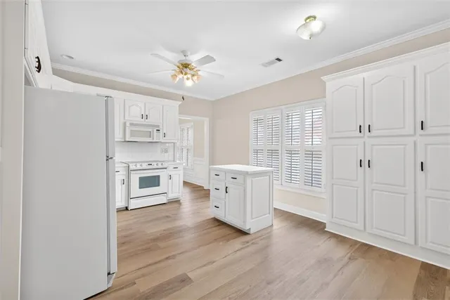 a view of kitchen with white cabinets and wooden floor