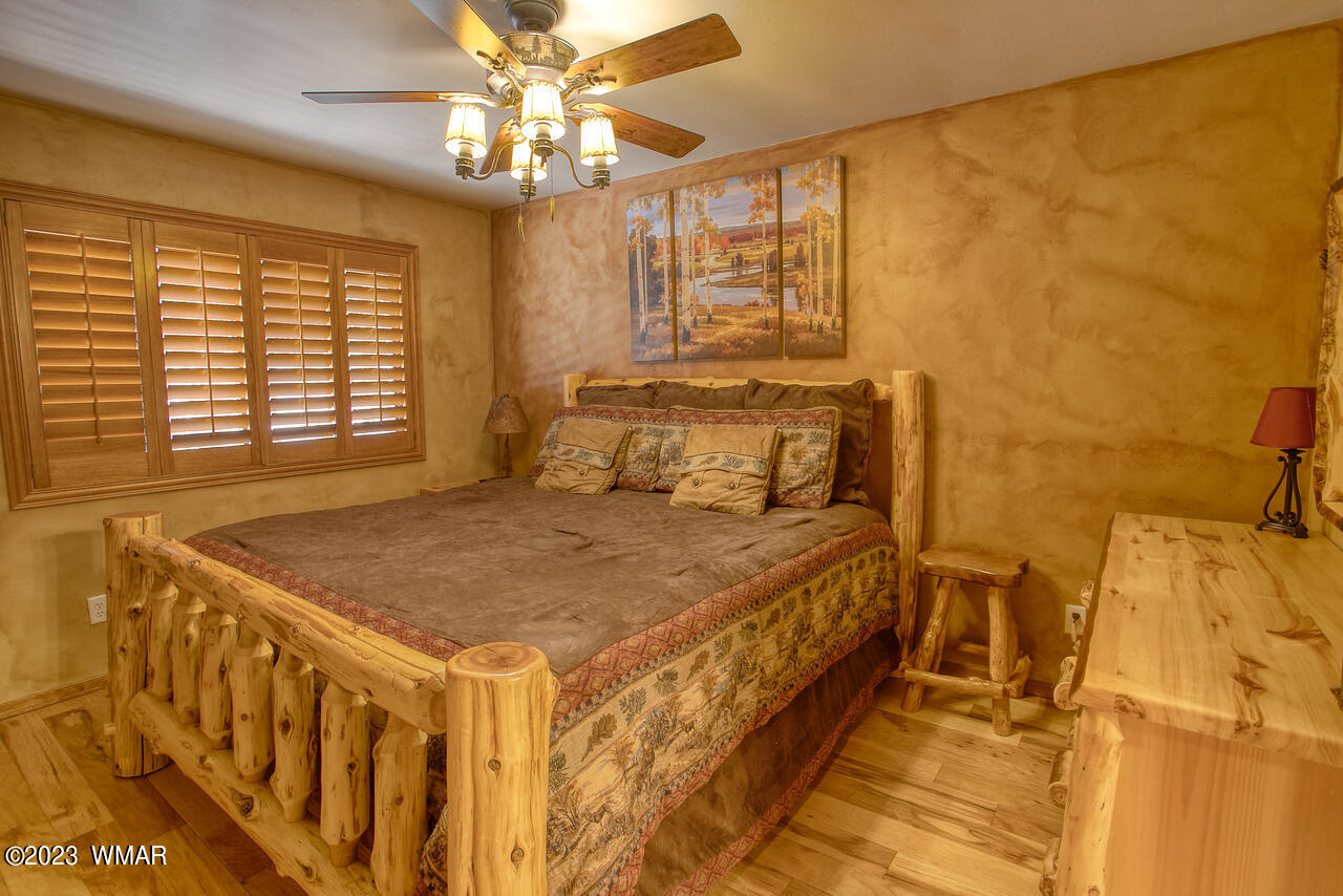 1911 North Bison Ridge Trail, Unit 10 Show Low, AZ 85901 - Photo 12 of 17 a bedroom with a bed and a chandelier