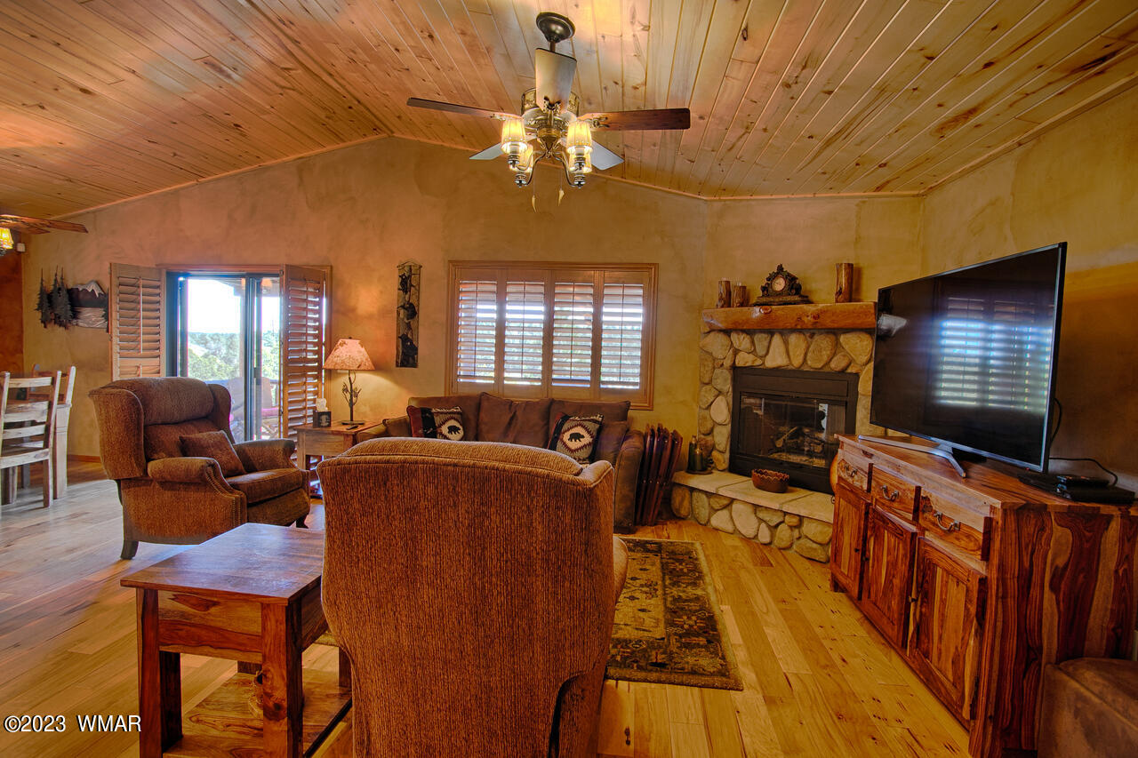 1911 North Bison Ridge Trail, Unit 10 Show Low, AZ 85901 - Photo 3 of 17 a living room with furniture a flat screen tv and floor to ceiling window