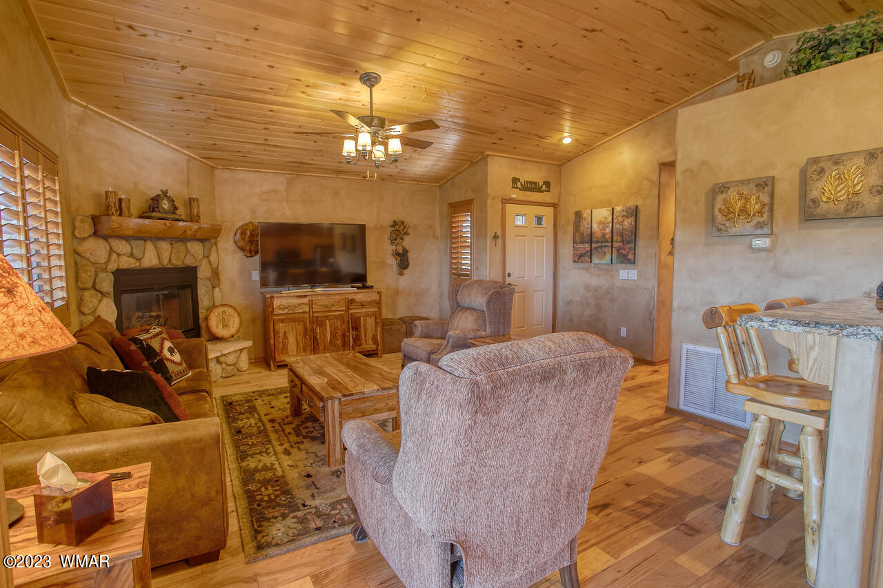 1911 North Bison Ridge Trail, Unit 10 Show Low, AZ 85901 - Photo 5 of 17 a living room with furniture a chandelier and a flat screen tv