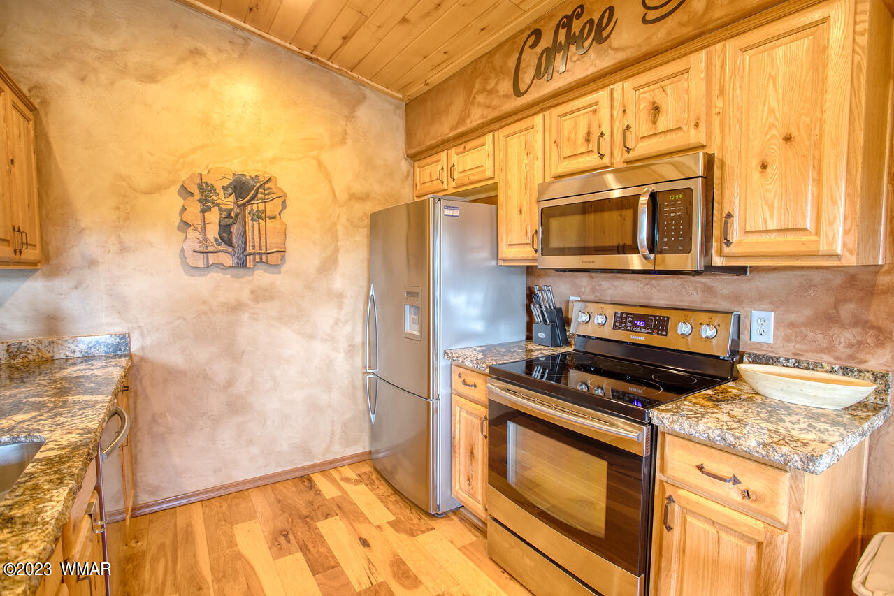1911 North Bison Ridge Trail, Unit 10 Show Low, AZ 85901 - Photo 6 of 17 a kitchen with stainless steel appliances granite countertop a stove and a microwave