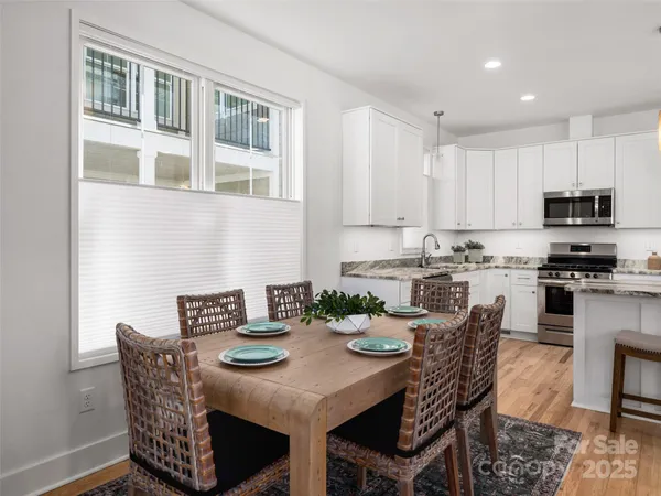 a kitchen with stainless steel appliances granite countertop a table and chairs
