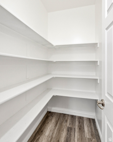 1177 Northfield Road, Unit 26 Cedar City, UT 84721 - Photo 15 of 45 Walk-in pantry featuring extensive built-in white shelving, wood-finish flooring, and white trim