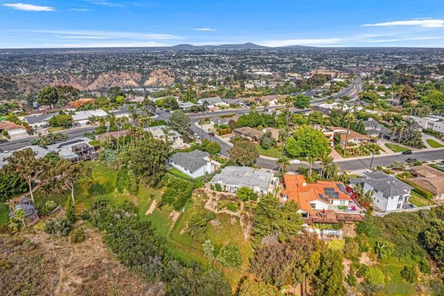 an aerial view of residential building with parking and yard