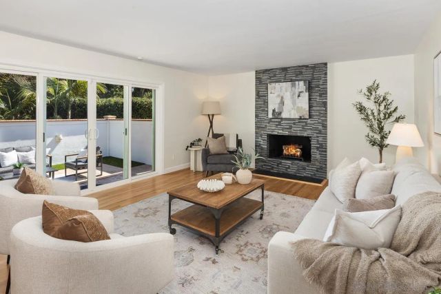 a living room with furniture fireplace and a large window