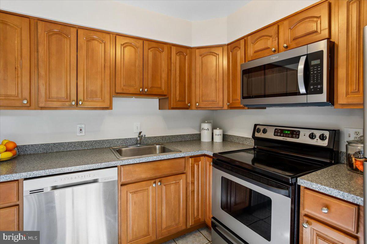 17804 Buehler Road, Unit 3D3 Olney, MD 20832 - Photo 9 of 32 a kitchen with stainless steel appliances granite countertop a sink stove and microwave