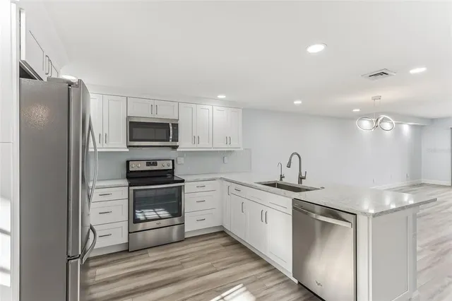 a bathroom with a granite countertop sink and white cabinets