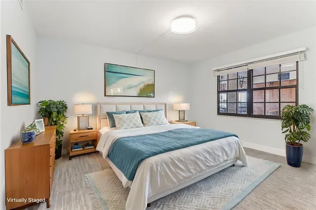 a bedroom with a bed and a potted plant