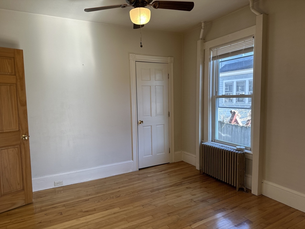 259 Albion Street, Unit 1 Wakefield, MA 01880 - Photo 5 of 14 a view of an empty room with wooden floor and a window