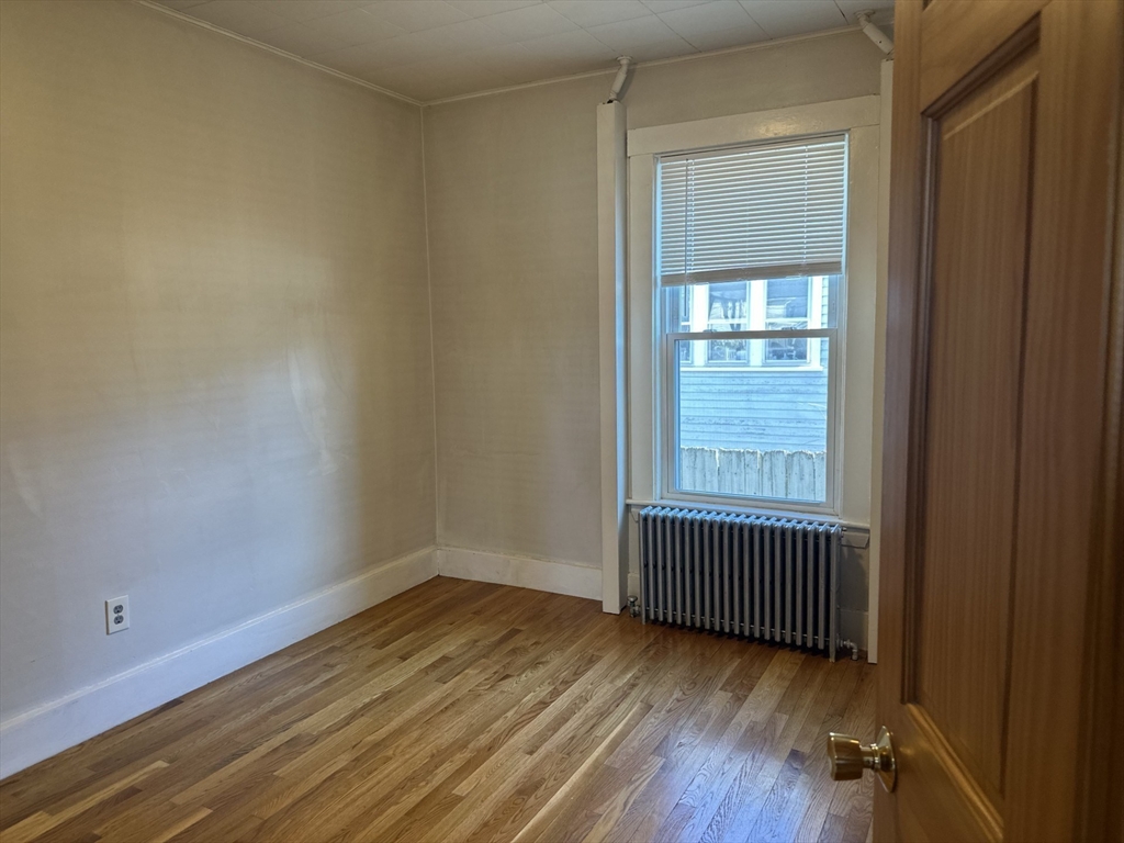 259 Albion Street, Unit 1 Wakefield, MA 01880 - Photo 10 of 14 an empty room with wooden floor and windows