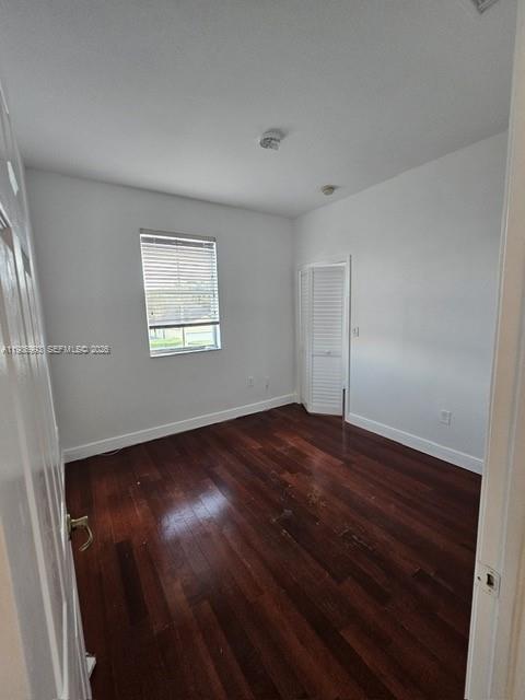 11151 Southwest 241st Street Homestead, FL 33032 - Photo 13 of 18 an empty room with wooden floor and windows