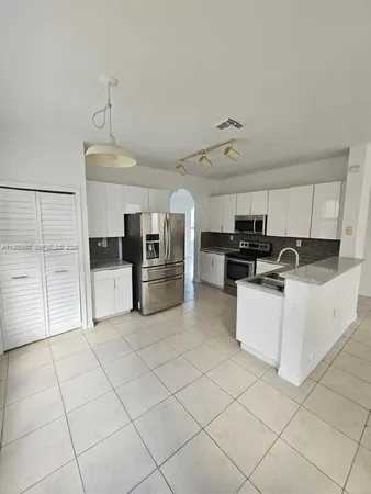 a large white kitchen with cabinets