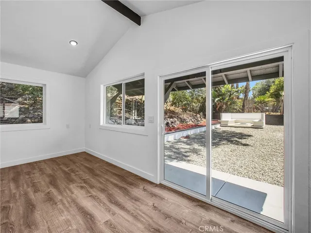 a view of empty room with wooden floor and floor to ceiling window