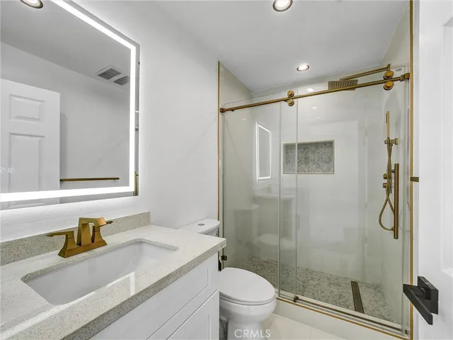 a bathroom with a granite countertop sink toilet and shower