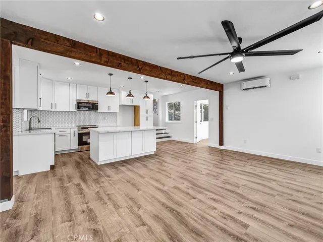 a view of kitchen with stainless steel appliances refrigerator stove microwave and cabinets