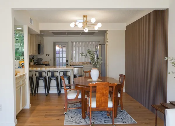 a view of a a dining room with furniture window and wooden floor