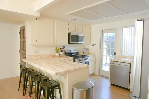 a kitchen with stainless steel appliances a stove a refrigerator and a dining table