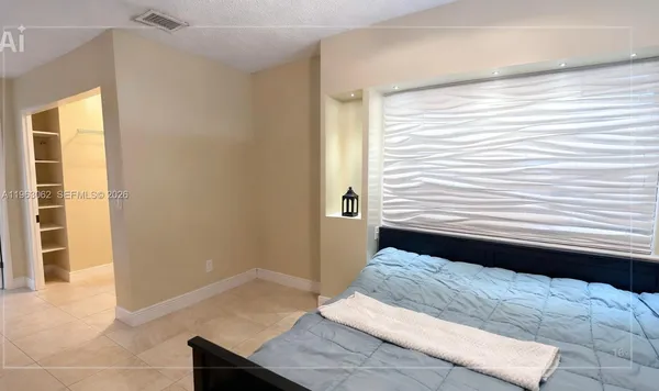 a view of a bedroom with wooden floor and windows
