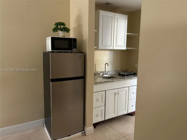 a kitchen with stainless steel appliances granite countertop a refrigerator a stove a microwave and sink