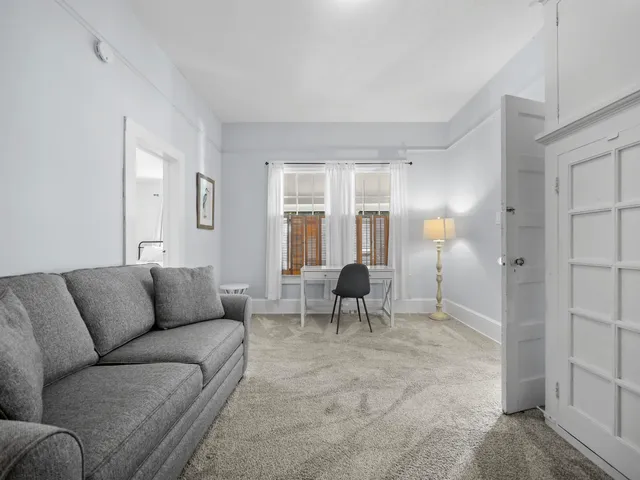 a living room with furniture and a dining table