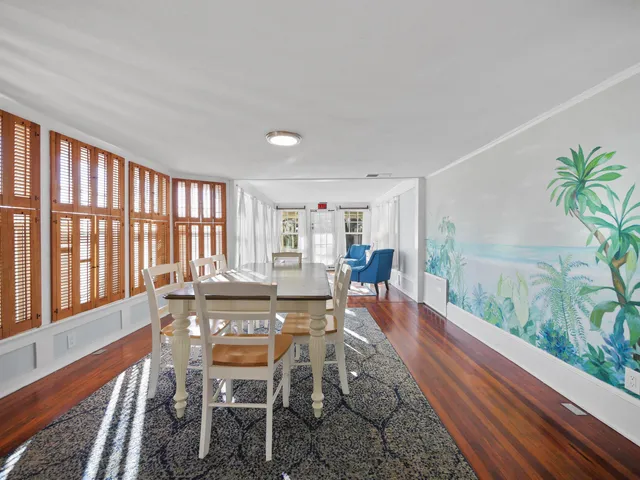 a dining room with furniture a rug and wooden floor
