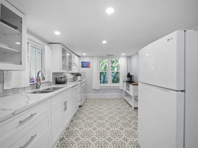 a kitchen with white cabinets and white appliances