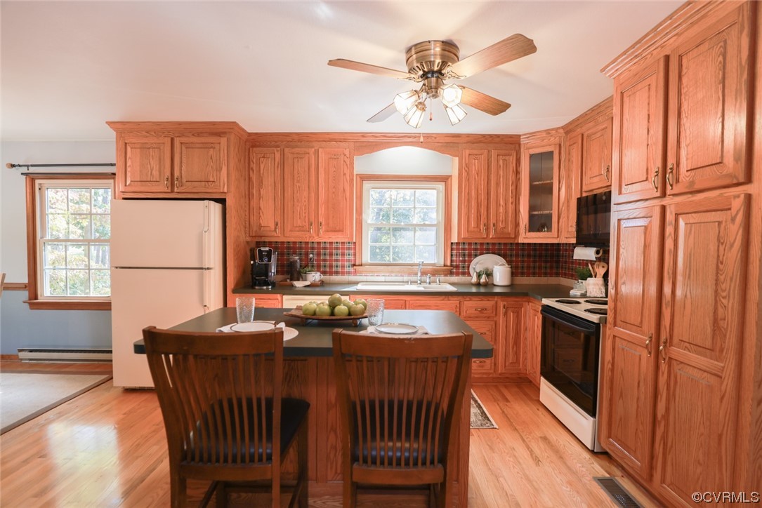 7317 Creighton Road Mechanicsville, VA 23111 - Photo 12 of 46 a kitchen with stainless steel appliances granite countertop a stove a sink dishwasher a refrigerator a dining table and chairs with wooden floor