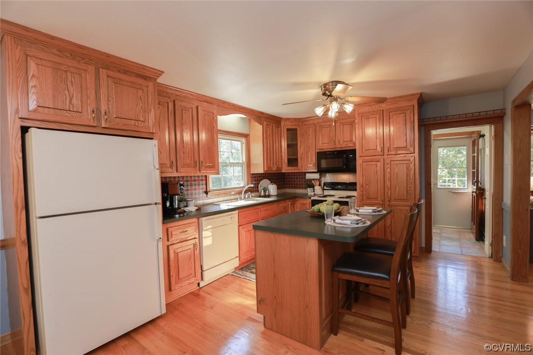 7317 Creighton Road Mechanicsville, VA 23111 - Photo 14 of 46 a kitchen with refrigerator a sink and chairs