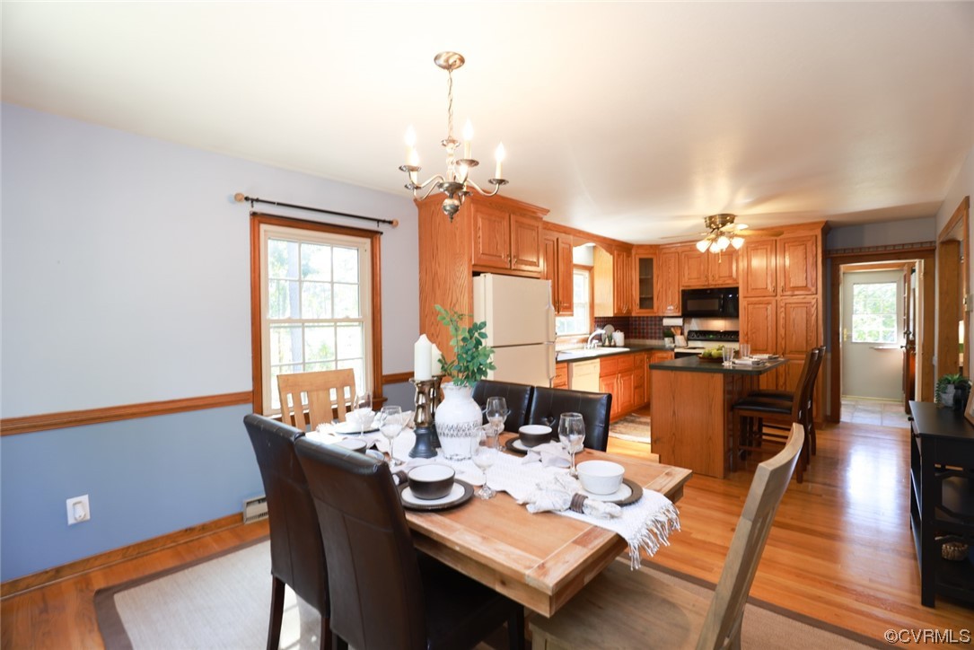 7317 Creighton Road Mechanicsville, VA 23111 - Photo 18 of 46 a dining room with wooden floor and a chandelier
