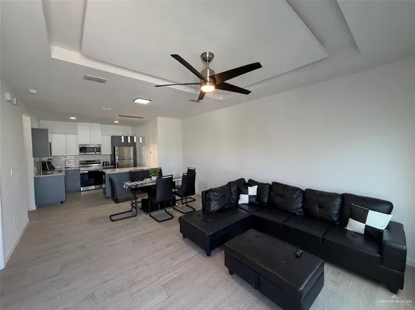 a living room with furniture and a ceiling fan