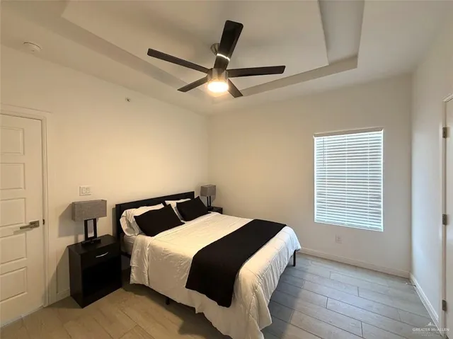 a bedroom with a bed and a ceiling fan