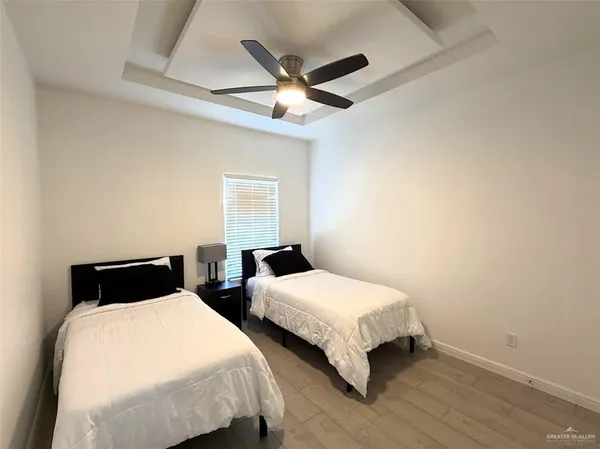 a bedroom with two beds and a ceiling fan