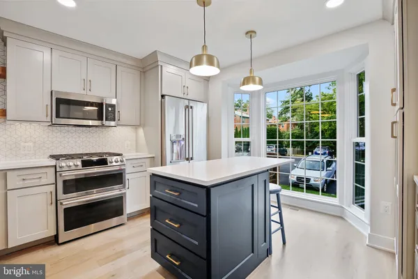 a kitchen with kitchen island granite countertop a stove and a sink