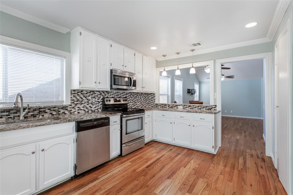 4139 Rosser Square Dallas, TX 75244 - Photo 14 of 34 Beautifully updated kitchen showcasing a stainless steel oven, built-in microwave, dishwasher, and tile backsplash.