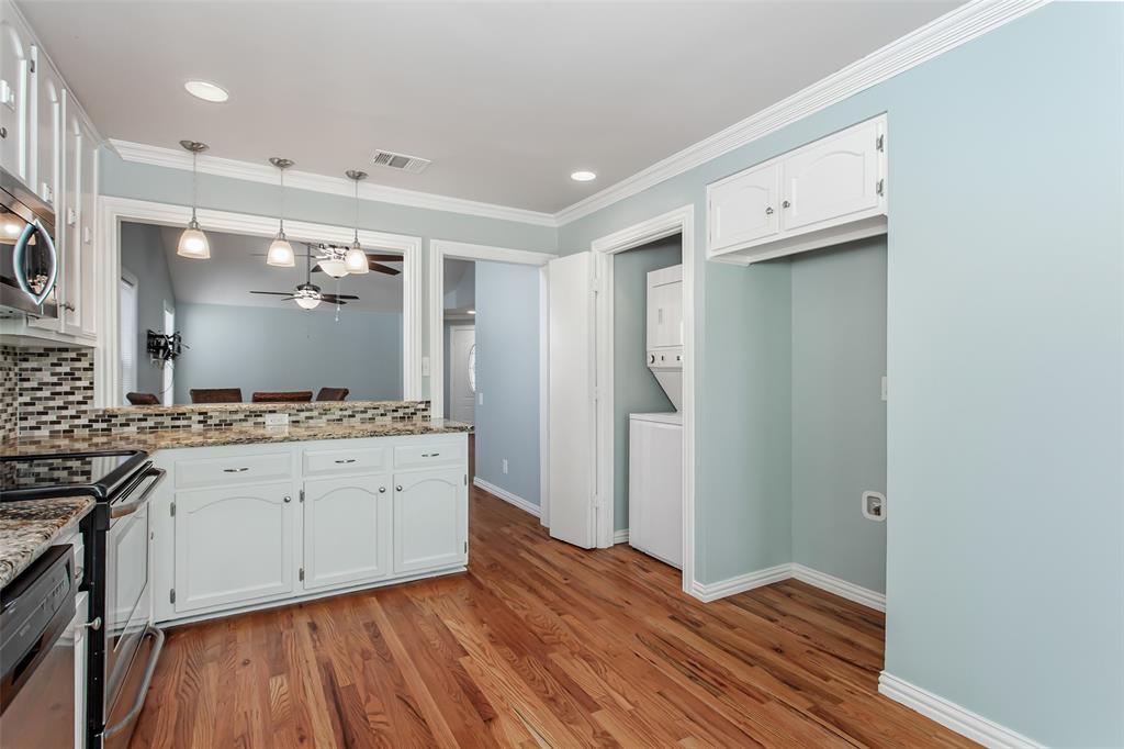4139 Rosser Square Dallas, TX 75244 - Photo 15 of 34 Inviting kitchen with a convenient pass-through breakfast bar, pendant lighting, and an open flow to the dining and living areas—perfect for entertaining.