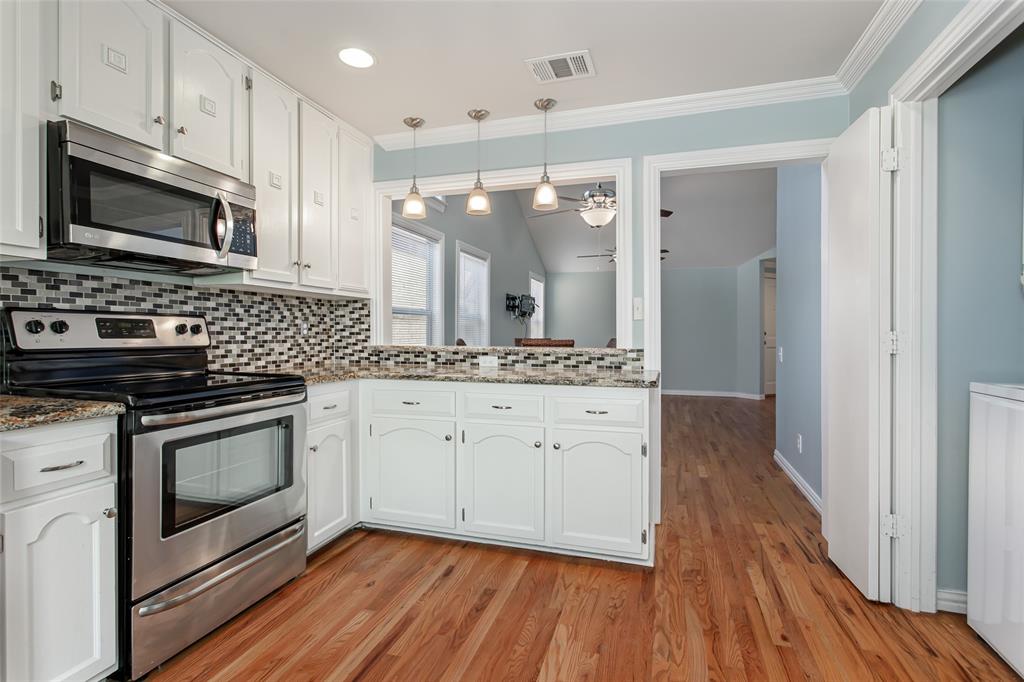 4139 Rosser Square Dallas, TX 75244 - Photo 17 of 34 Stunning kitchen with warm hardwood floors and an open layout that seamlessly connects to the main living spaces.