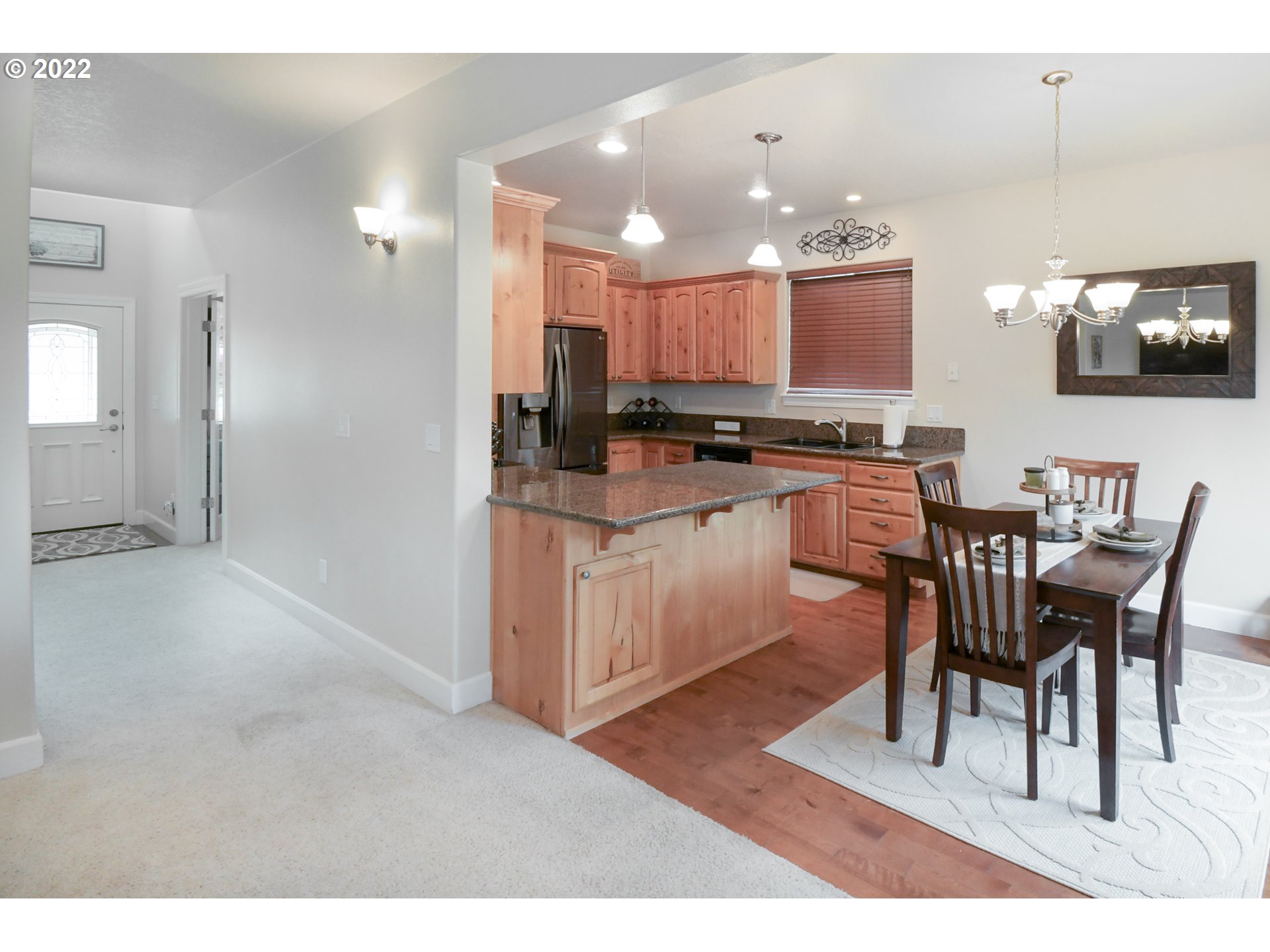 901 T Street Springfield, OR 97477 - Photo 5 of 29 a kitchen with kitchen island granite countertop wooden floors and white cabinets