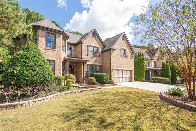 a front view of a house with yard and tress