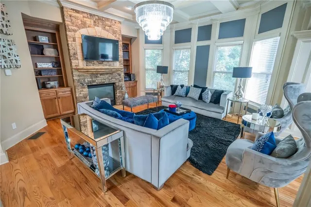 a living room with furniture a fireplace and a chandelier