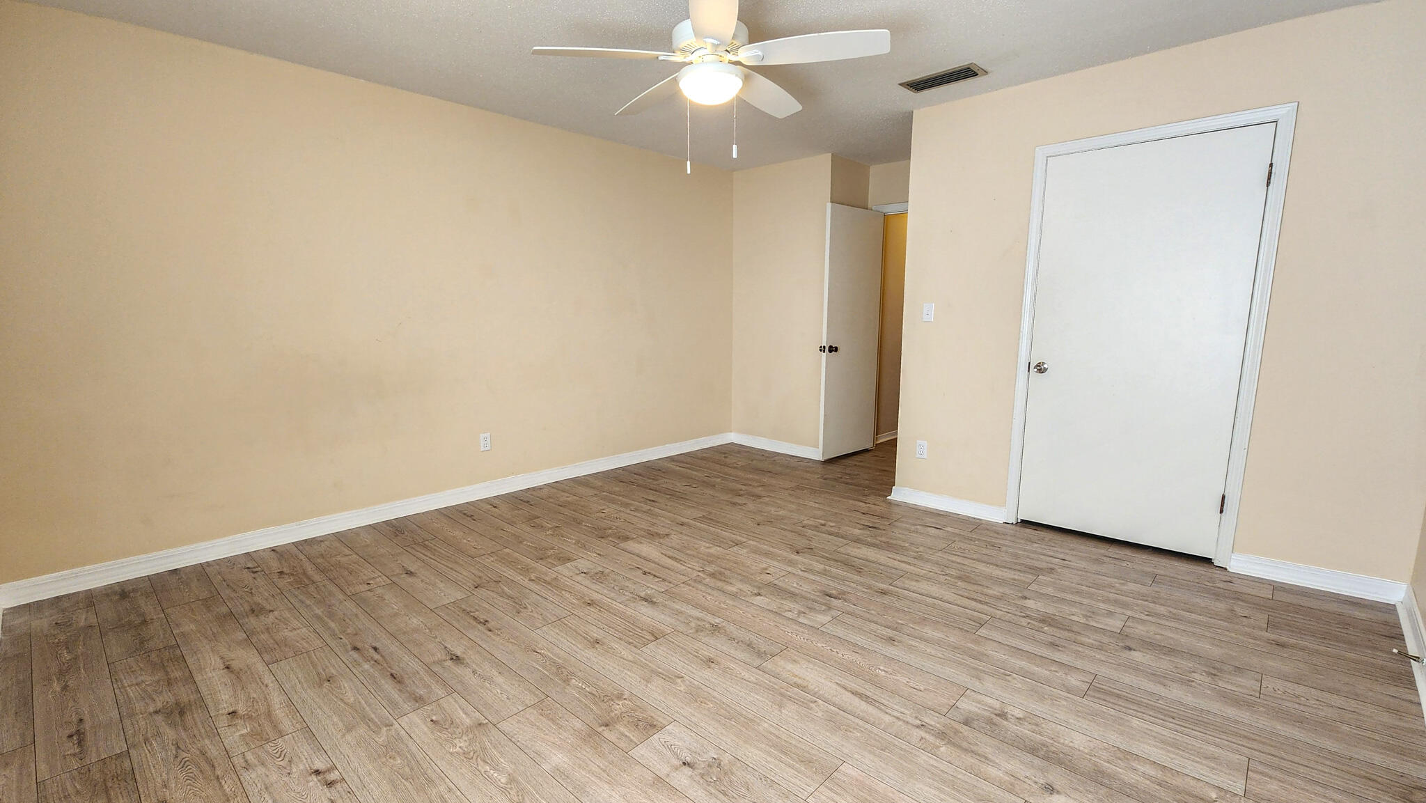 145 4th Avenue, Unit B3 Shalimar, FL 32579 - Photo 27 of 28 a view of an empty room with wooden floor and a ceiling fan
