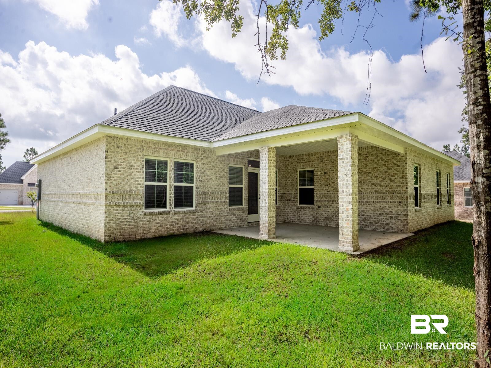 12942 Gondala Street Elberta, AL 36530 - Photo 2 of 18 Back of house featuring brick siding, a patio, a shingled roof, and a yard