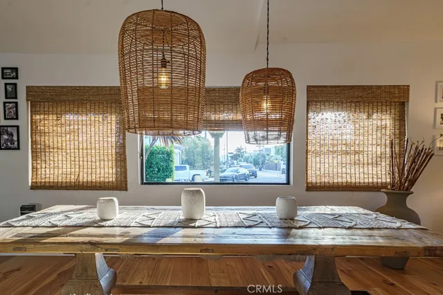 a living room with stainless steel appliances furniture wooden floor and a kitchen view